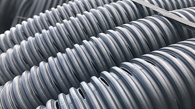 Small round holes or slots are the most common type of perforation in land drain pipes.